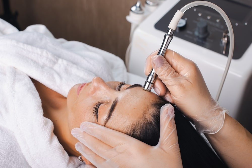 Woman applying facial treatment to face